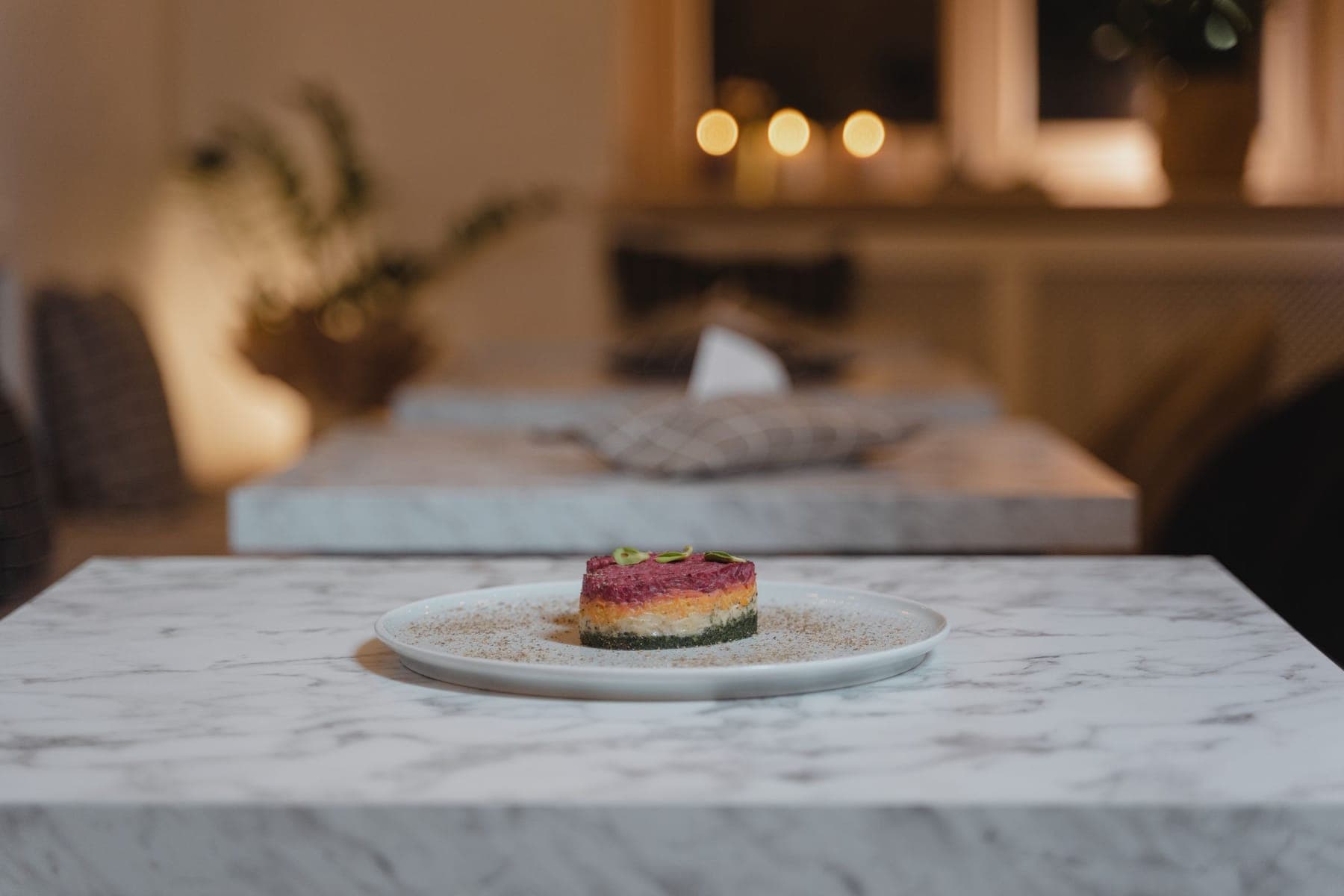 A plated dish on a marble table in a dim restaurant