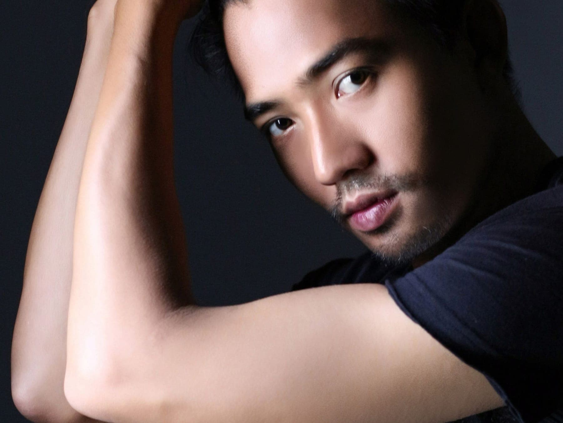 A dramatic studio portrait with an arm raised