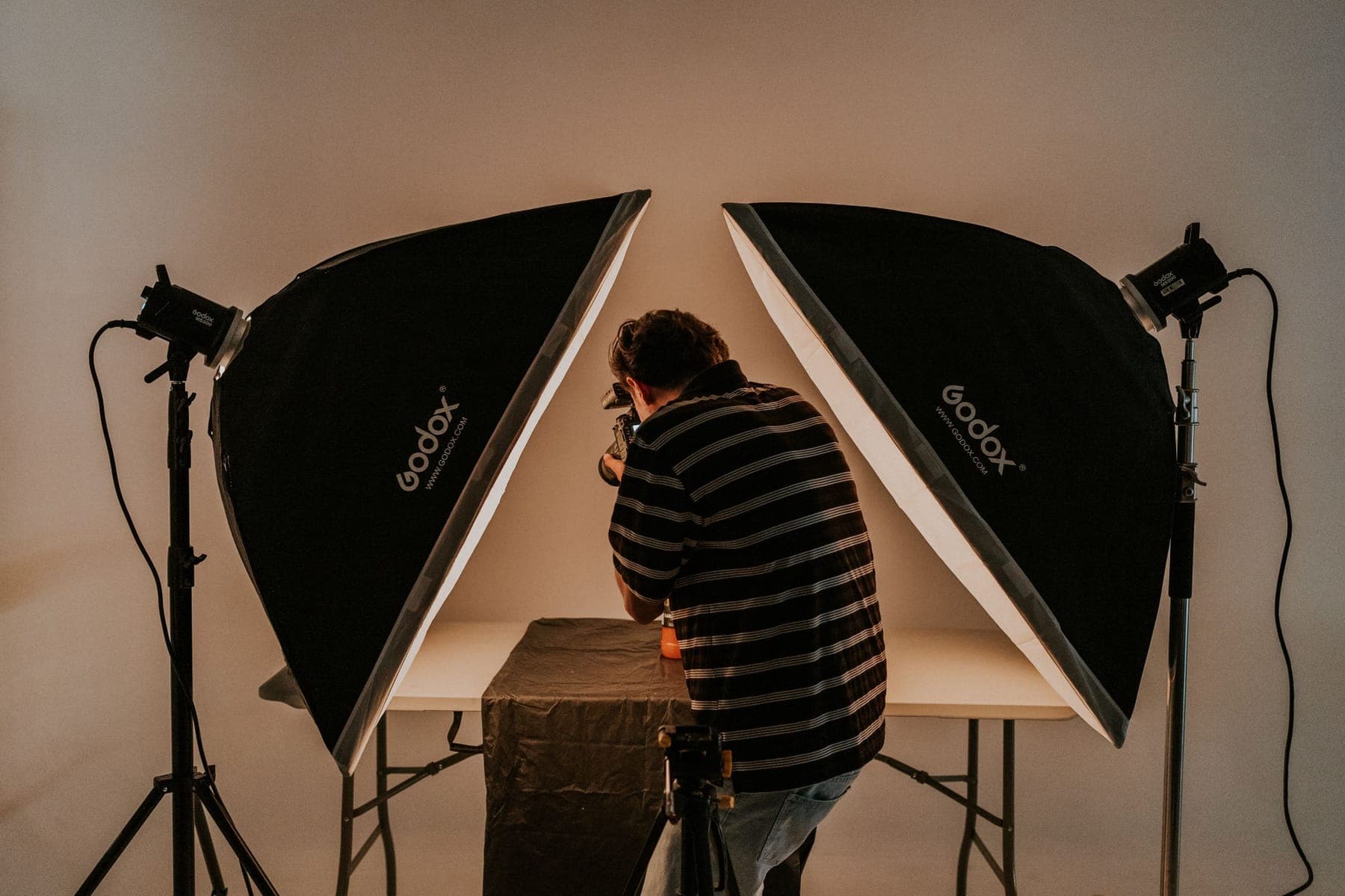 A photographer between two softboxes, seen from behind